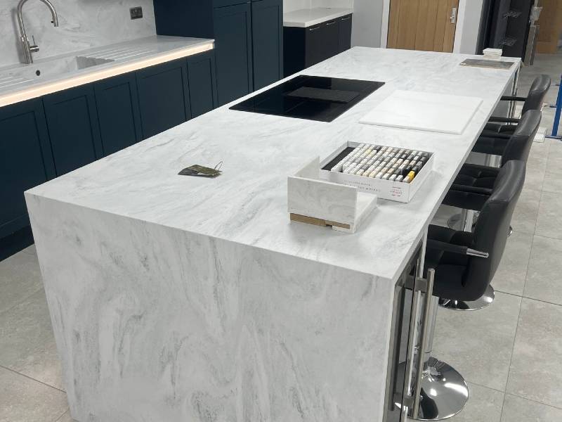A kitchen with a white marble counter top.